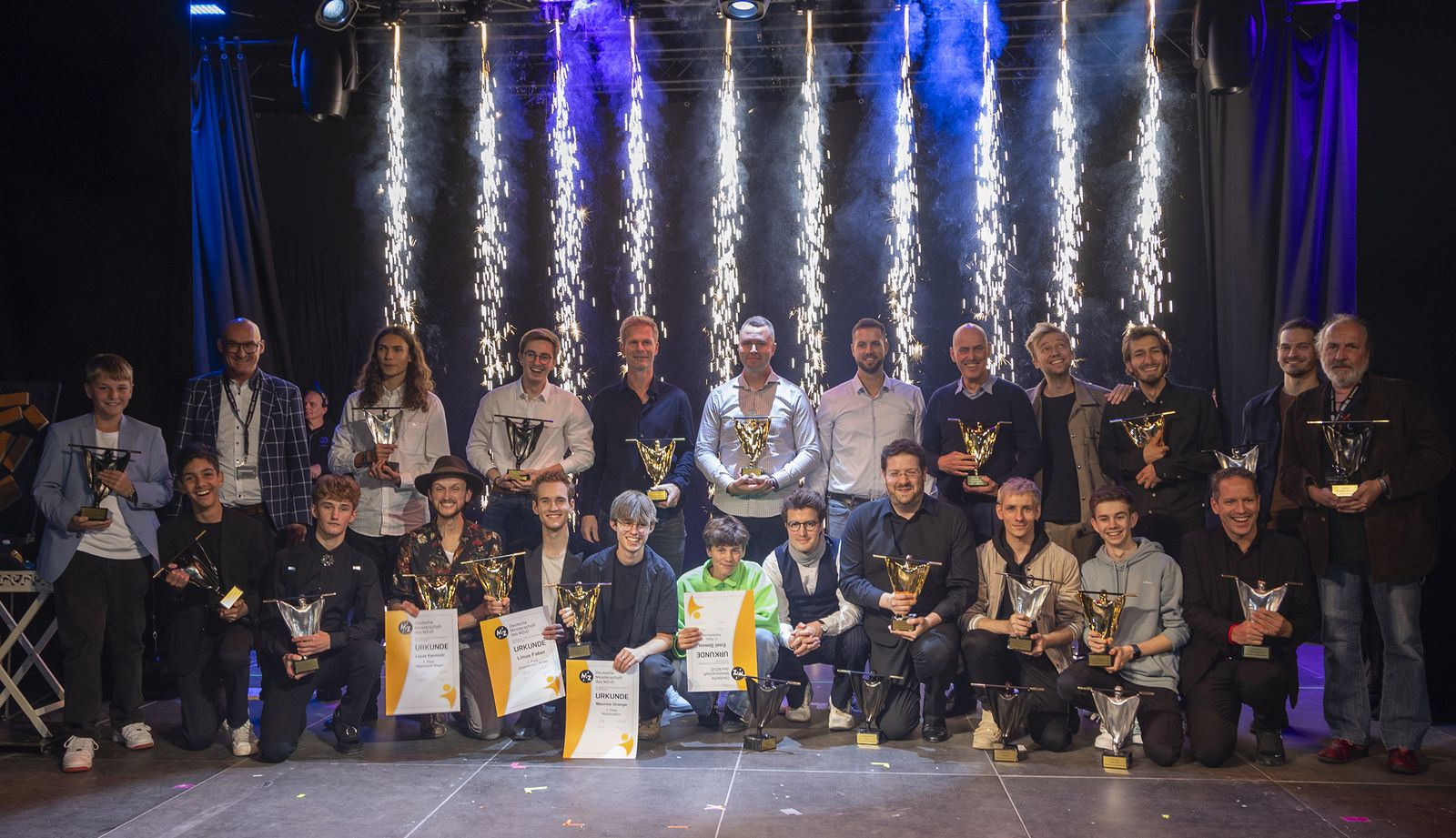 Alle Preisträger der Meisterschaften der Zauberkunst 2024 mit ihren MAGICA-Trophäen auf der Bühne in Lübeck