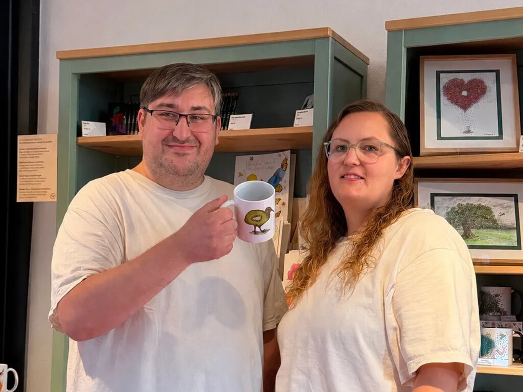 Sascha und Katharina Pfeuffer von Key Moments, er hält eine selbst bedruckte Tasse mit Küken-Motiv