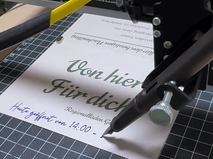 Der Handschriftautomat schreibt mit einem echten Stift eine handschriftliche Zeile auf eine vorgedruckte Karte